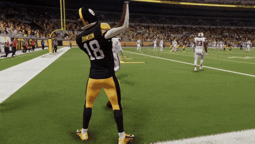 a football player with the number 18 on his jersey stands on the field