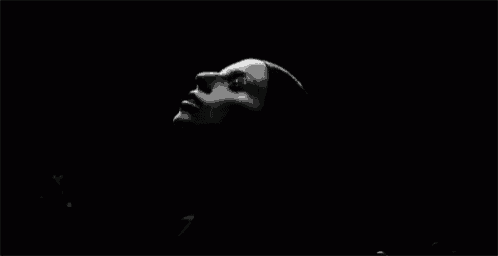 a black and white photo of a woman with her eyes closed and her hands in the air .
