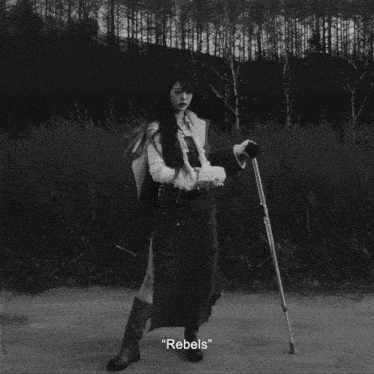 a black and white photo of a woman holding crutches with the words rebels written below her