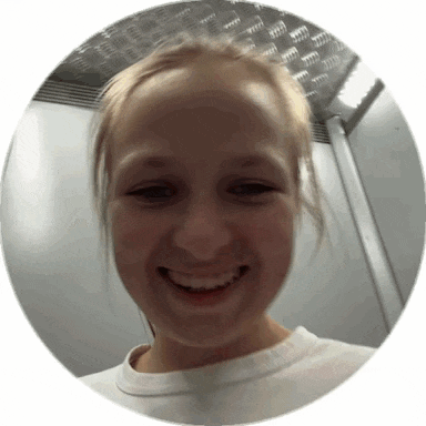 a girl is smiling in a circle with a metal ceiling in the background