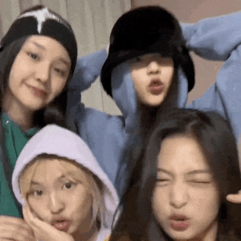 a group of four young women are posing for a picture together .