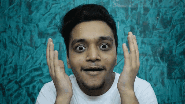 a man with his hands on his face making a surprised face
