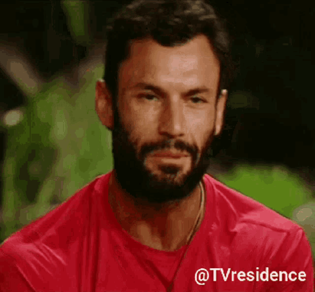 a man with a beard is wearing a red shirt that says tvresidence on it