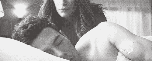 a man and a woman are laying in bed together .
