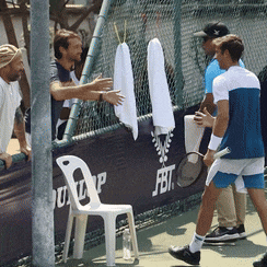 a group of men are standing in front of a fence with a fbt logo on it