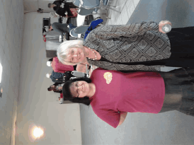two women are posing for a picture and one is wearing a shirt that says ' california ' on it