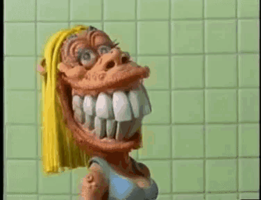 a cartoon character with a large mouth and teeth is standing in a bathroom .