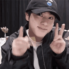 a man wearing a sesame street hat is giving the peace sign