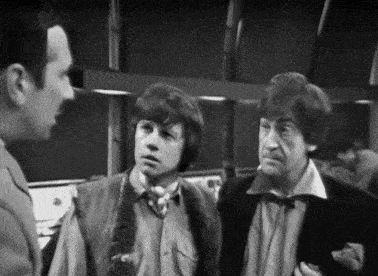 three men are talking to each other in a black and white photo .