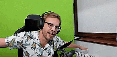 a man wearing headphones and glasses is sitting in a chair in front of a green wall .