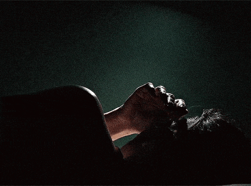 a person is laying down with their hands on their head