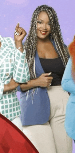 a woman with braids is smiling while standing next to two other women .
