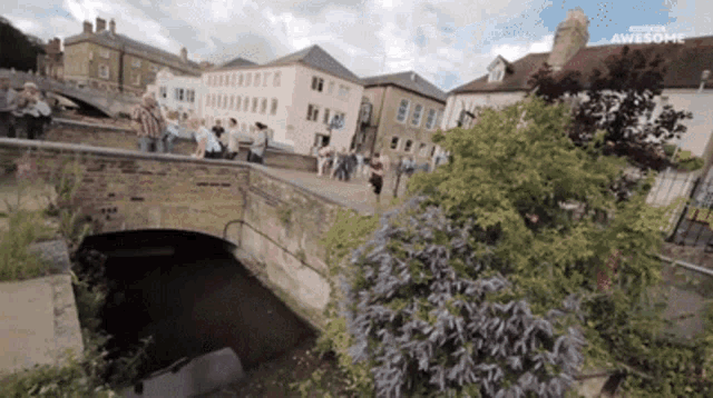 a group of people are walking across a bridge with the words museum awesome on the bottom right