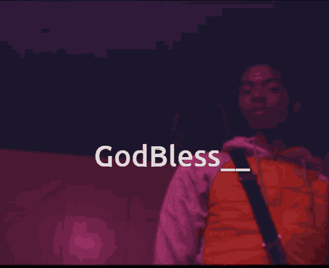 a man in a red shirt is holding a guitar and the words godbless_ appear above him