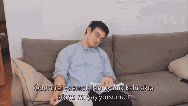 a man is sitting on a couch with the words " odevini yapmak için uyank kalmakta sikinti mi yaşiyorsunuz "