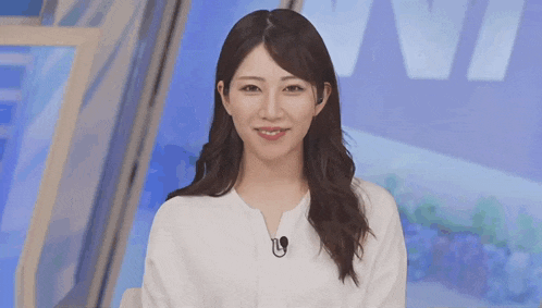 a woman wearing a white shirt and a microphone on her neck