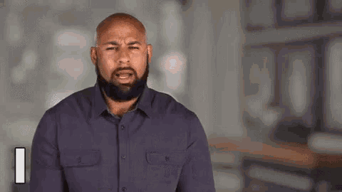 a bald man with a beard is making a funny face and says `` i am '' .
