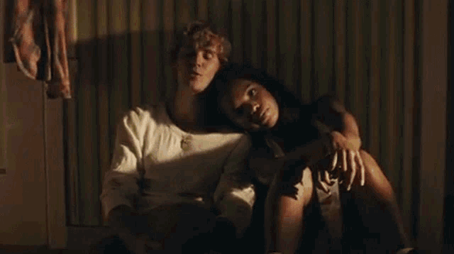 a man and woman are sitting next to each other on the floor .