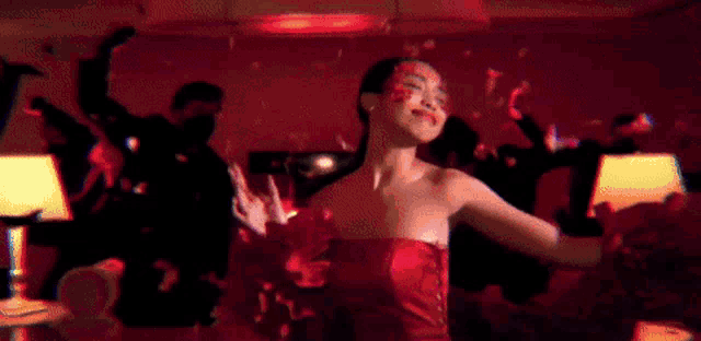 a woman in a red dress is dancing in a room