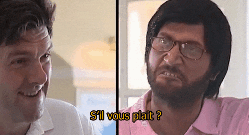 a man with glasses and a beard is talking to another man in a pink shirt ..