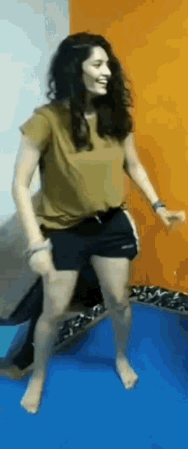 a woman is dancing on a trampoline while a man sits on her lap .
