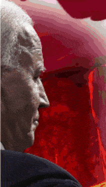 a close up of a man 's face with a red background behind him