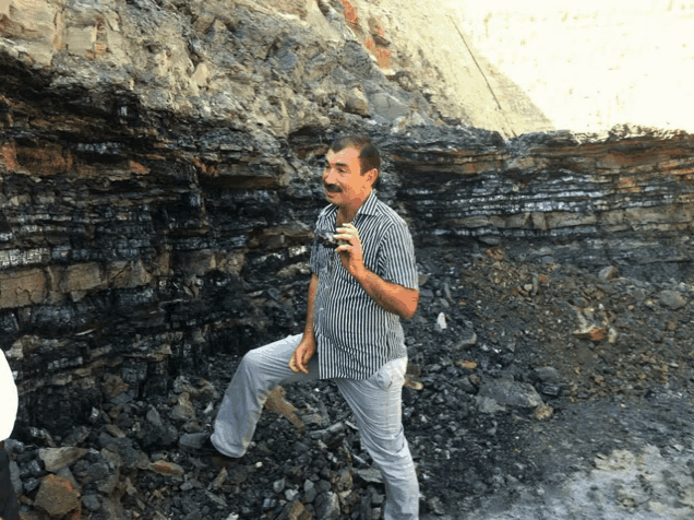 a man standing in front of a pile of rocks