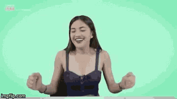 a woman in a blue bra is sitting at a table with her arms outstretched .