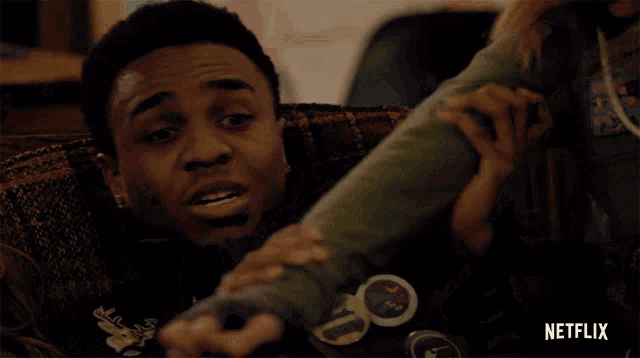 a man is laying on a couch with a netflix logo on the bottom right