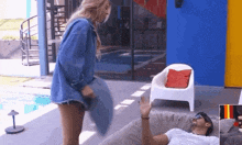 a woman is throwing a pillow at a man who is laying on a couch .