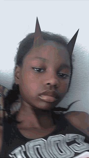 a girl with horns on her head is wearing a black shirt that says kings