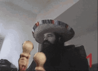 a man with a beard wearing a sombrero holds maracas