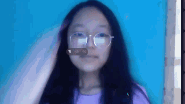 a young girl wearing glasses and a purple shirt is looking at the camera .