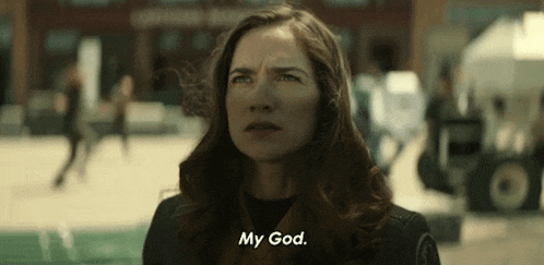 a woman is standing in front of a building and talking to her god .