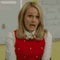 a woman is making a funny face in front of a white board .