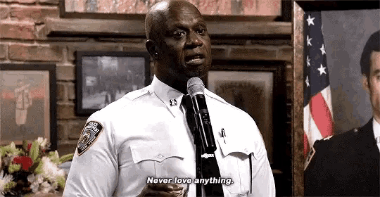 a man in a police uniform is holding a microphone and talking into it .