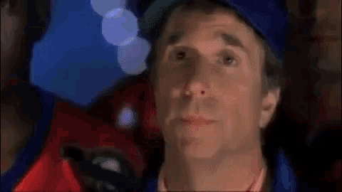 a close up of a man 's face wearing a baseball cap and a red shirt .