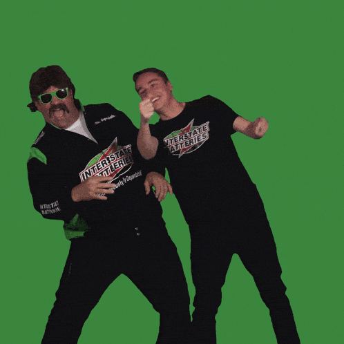 two men wearing shirts that say interstate batteries are dancing
