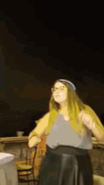 a woman in a gray top and black skirt is dancing