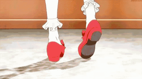 a close up of a person 's feet wearing red shoes and white socks .