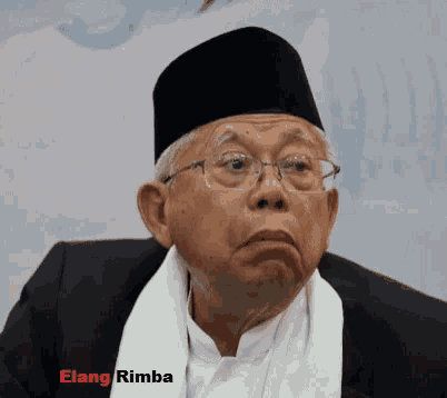 a man wearing glasses and a black hat with the name elang rimba written below him
