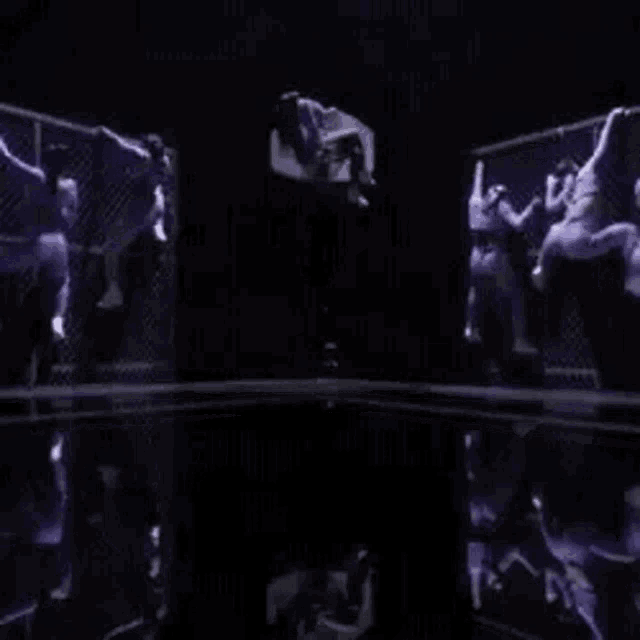 a group of people are doing a trick in a dark room .