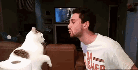 a man is kissing a cat on the cheek while wearing a shirt that says da fisher