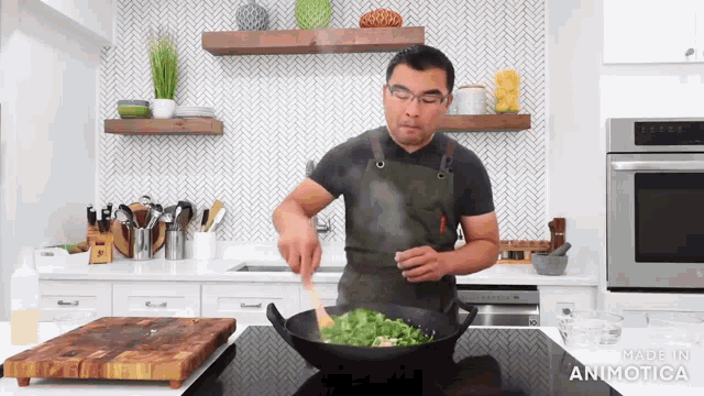 a man in an apron stirs vegetables in a wok with made in animatica written on the bottom