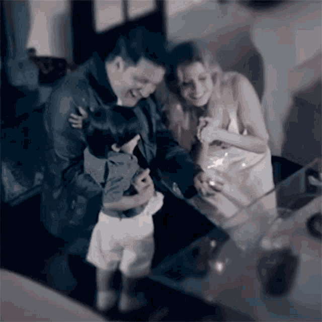 a man and a woman holding a child while a woman looks on