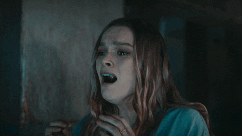 a woman with a ring on her finger is screaming with her mouth open