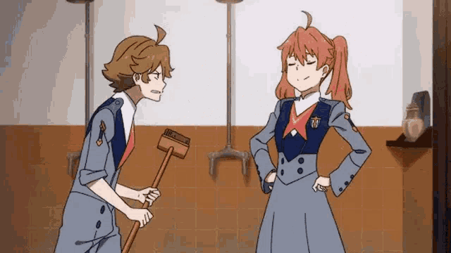 a man and a woman are standing next to each other in a bathroom with a mop .