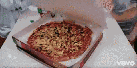 a pizza in a box on a table with the word vevo on it .