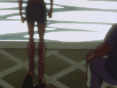 a woman in shorts is standing in front of a man in a blue shirt