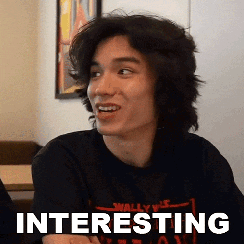 a young man wearing a black shirt with the word interesting written on it